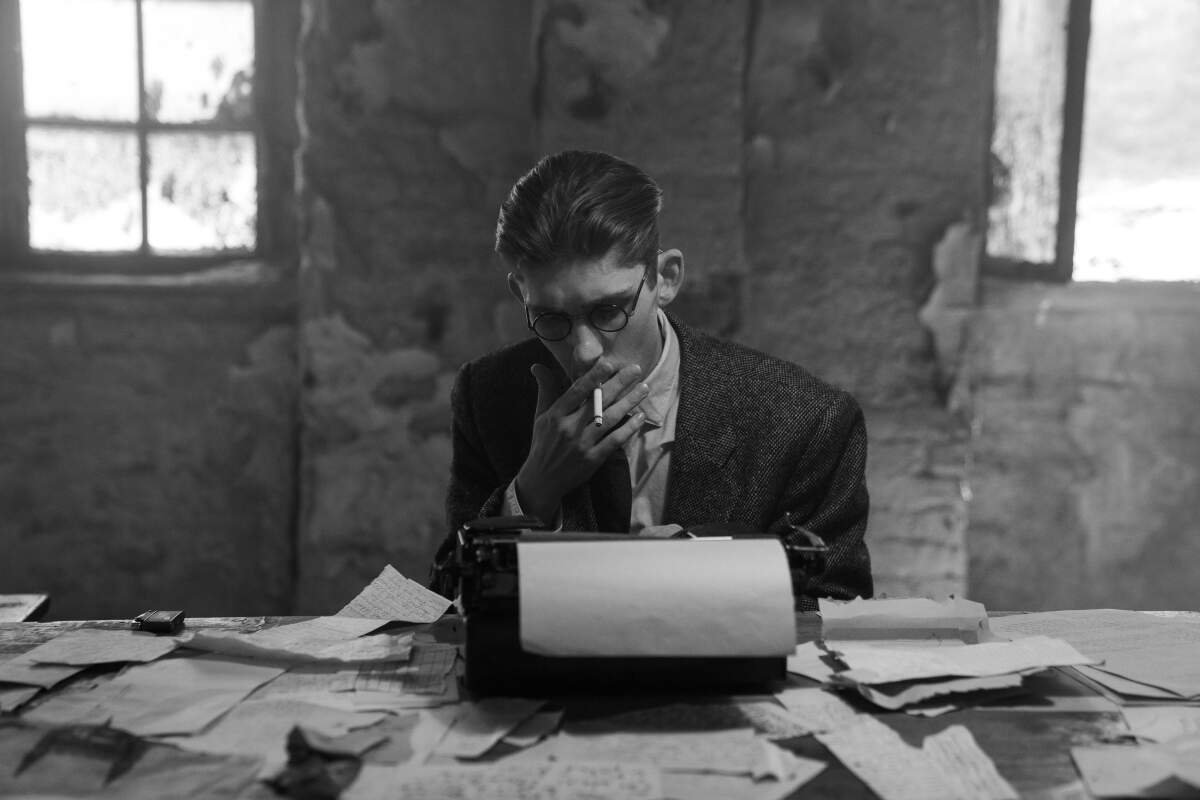 A young man smokes on a typewriter.